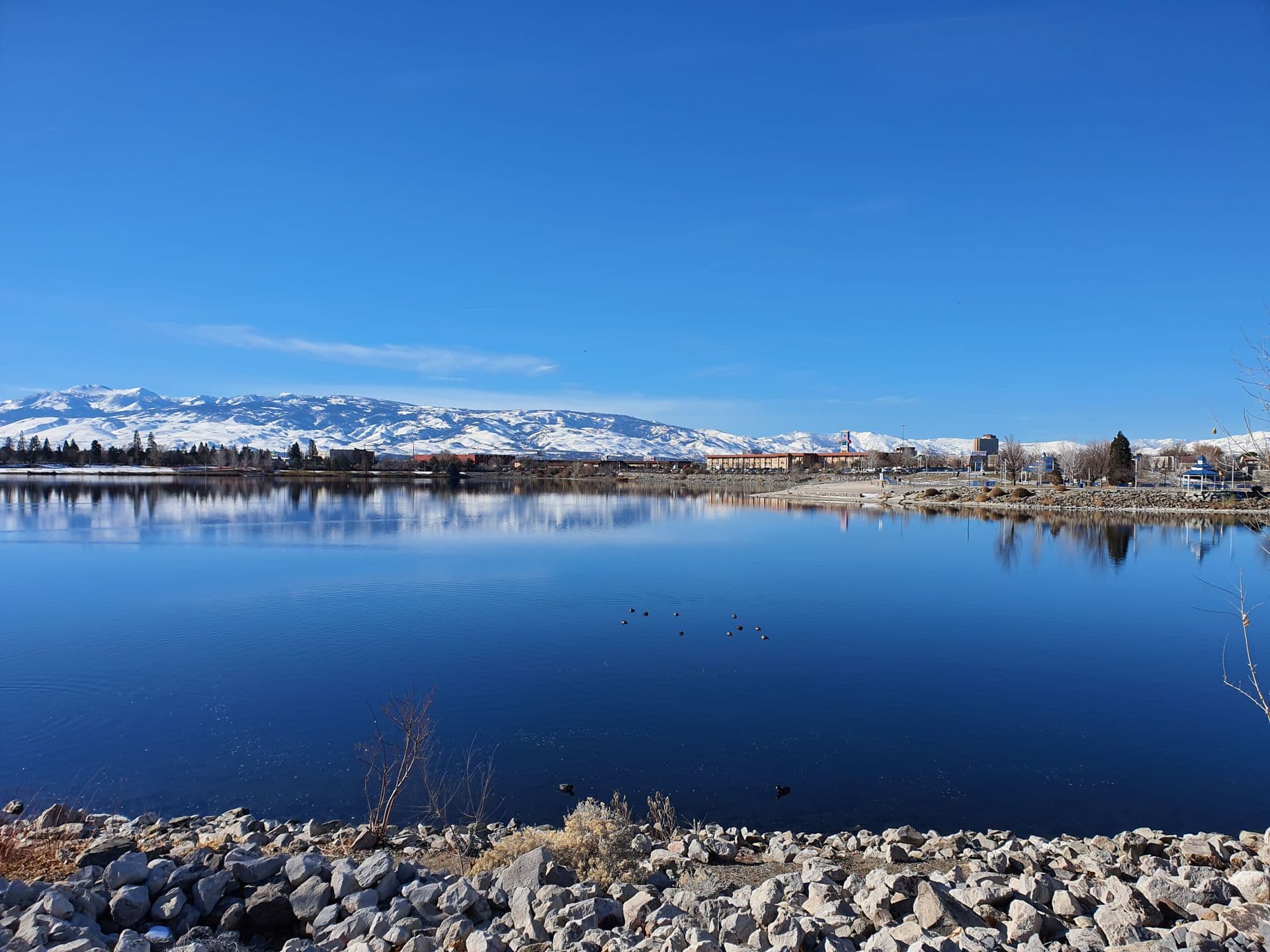 Boat docks on the Sparks Marina with snow-capped Peavine Peak and the Sierra rising behind the north valley skyline.