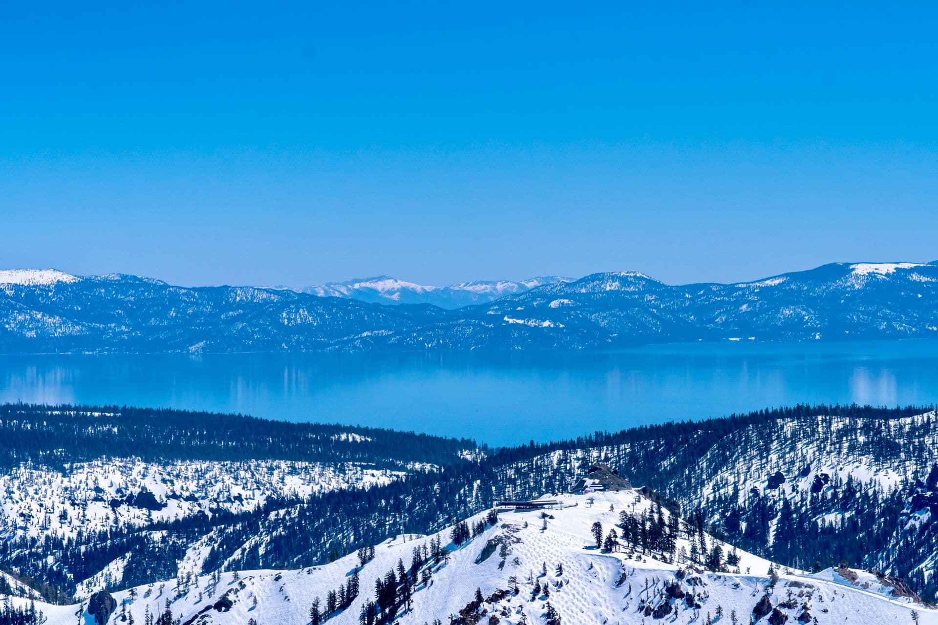 Wide view of Lake Tahoe and the Sierra Nevada range under a deep blue sky, the heart of Still Window Co's Northern Nevada service area.